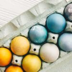 yellow blue and white Easter eggs in carton
