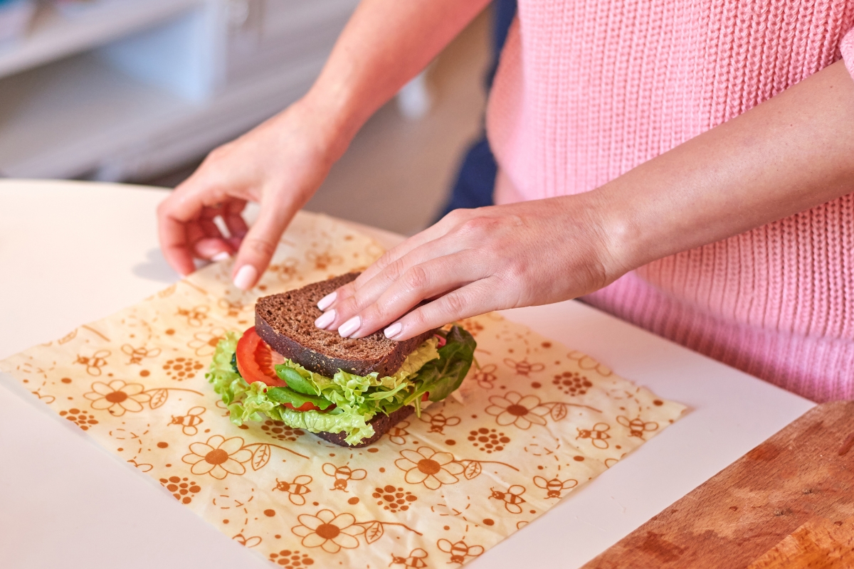 cropped photo of woman wrapping a sandwich in a bees wax wrap