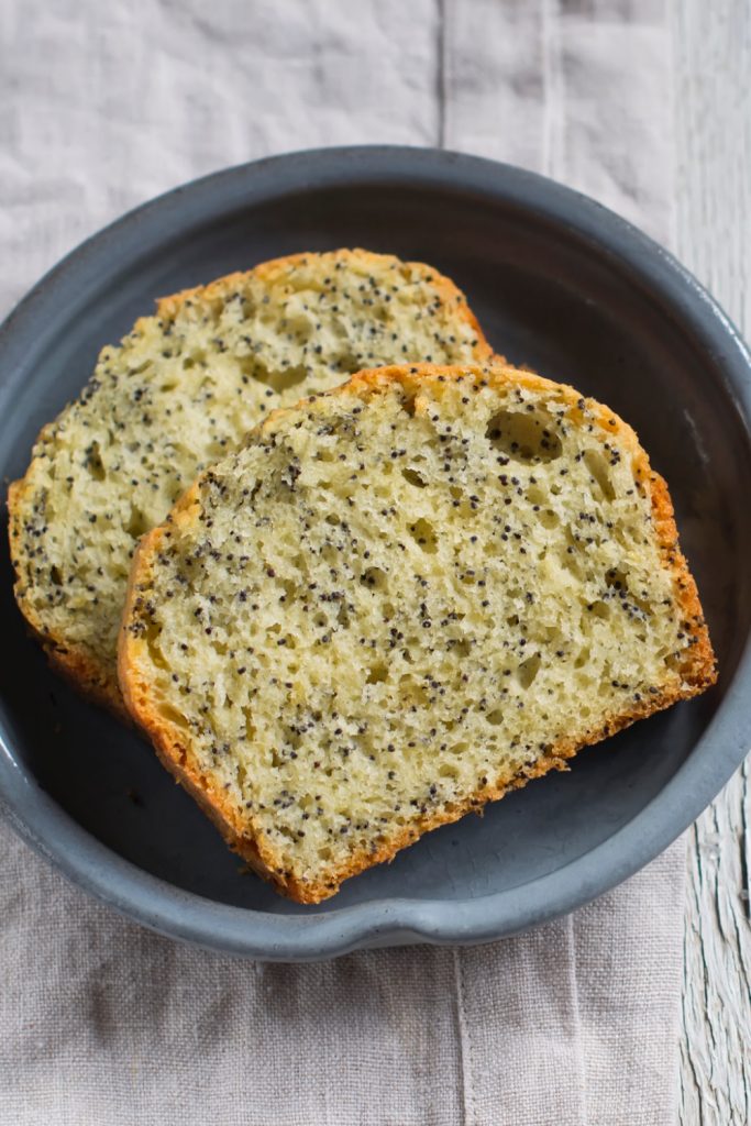 gluten-free lemon poppy seed bread on grey plate on white table