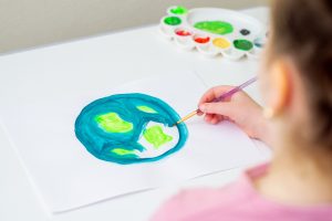 kid painting earth on white paper